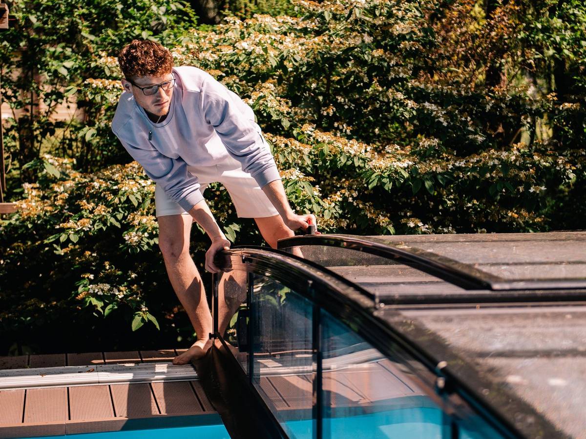 Ein Jugendlicher öffnet eine Poolabdeckung