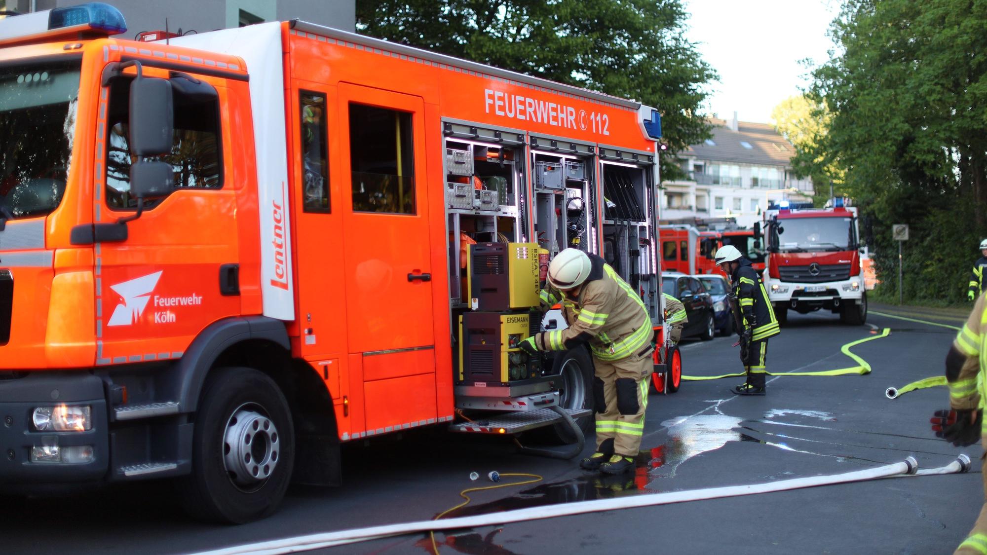 Mehrere Fahrzeuge der Feuerwehr stehen in einer Straße, mehrere Wehrmänner sind im Einsatz.