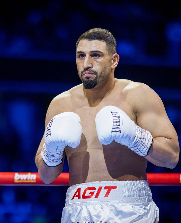Agit Kabayel steht im Ring und trägt weiße Boxhandschuhe.