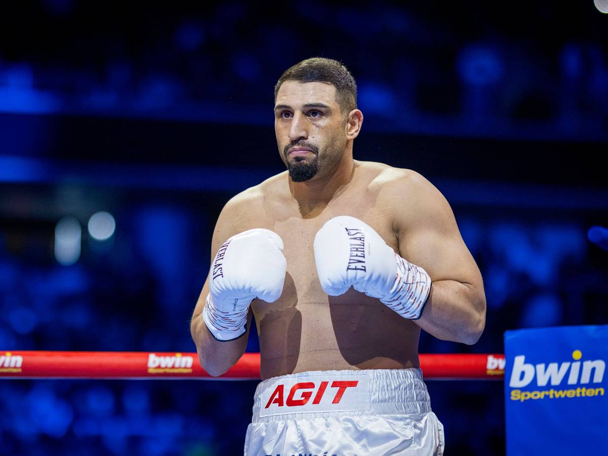 Agit Kabayel steht im Ring und trägt weiße Boxhandschuhe.