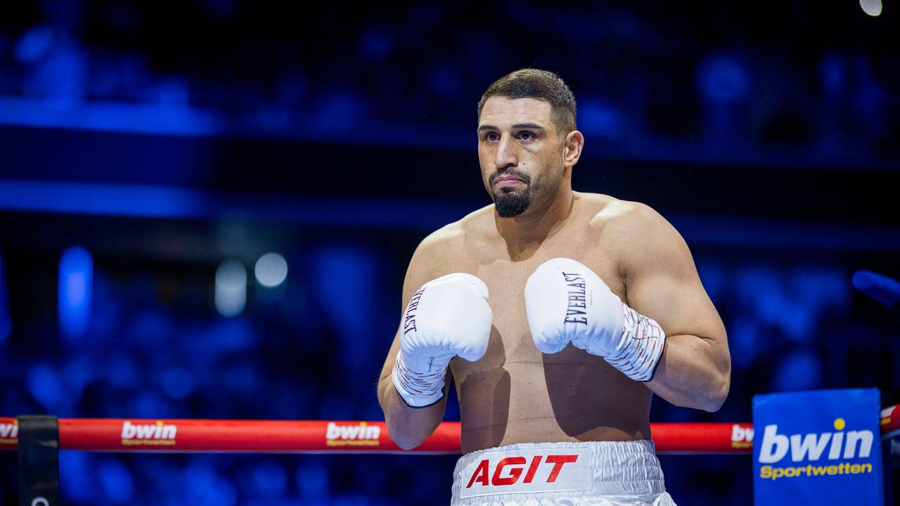 Agit Kabayel steht im Ring und trägt weiße Boxhandschuhe.