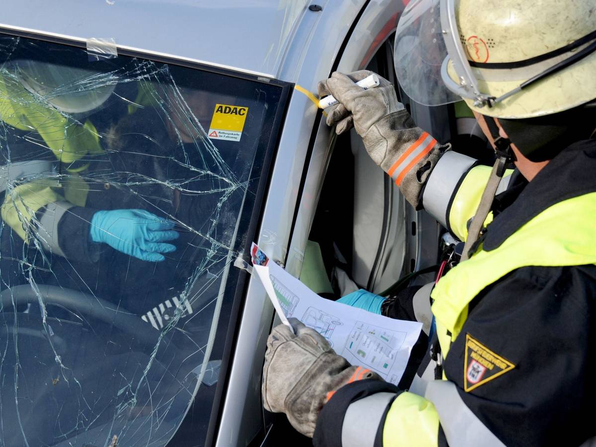 Rettungskräfte bei der Bergung einer Person aus einem Auto