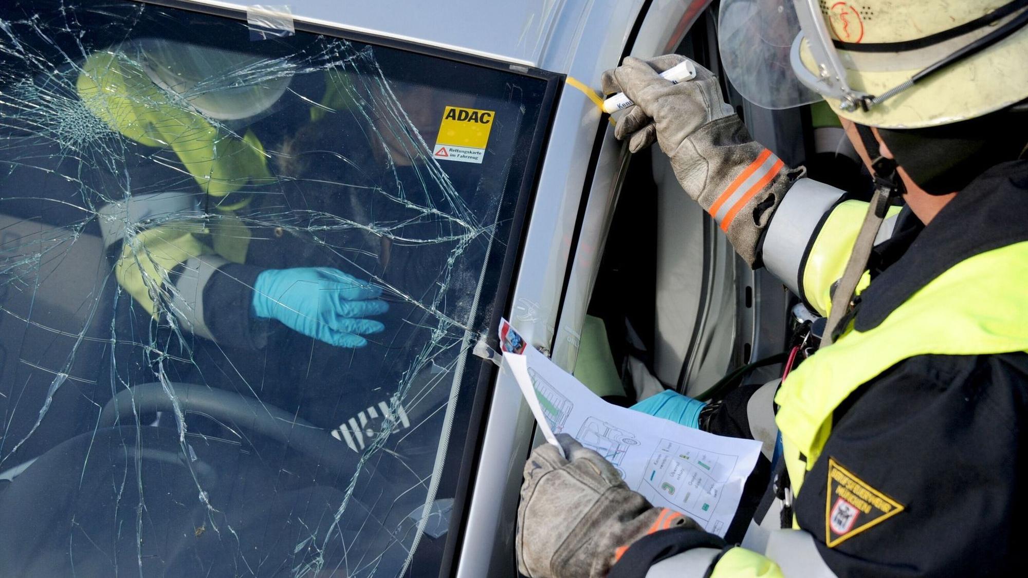 Rettungskräfte bei der Bergung einer Person aus einem Auto