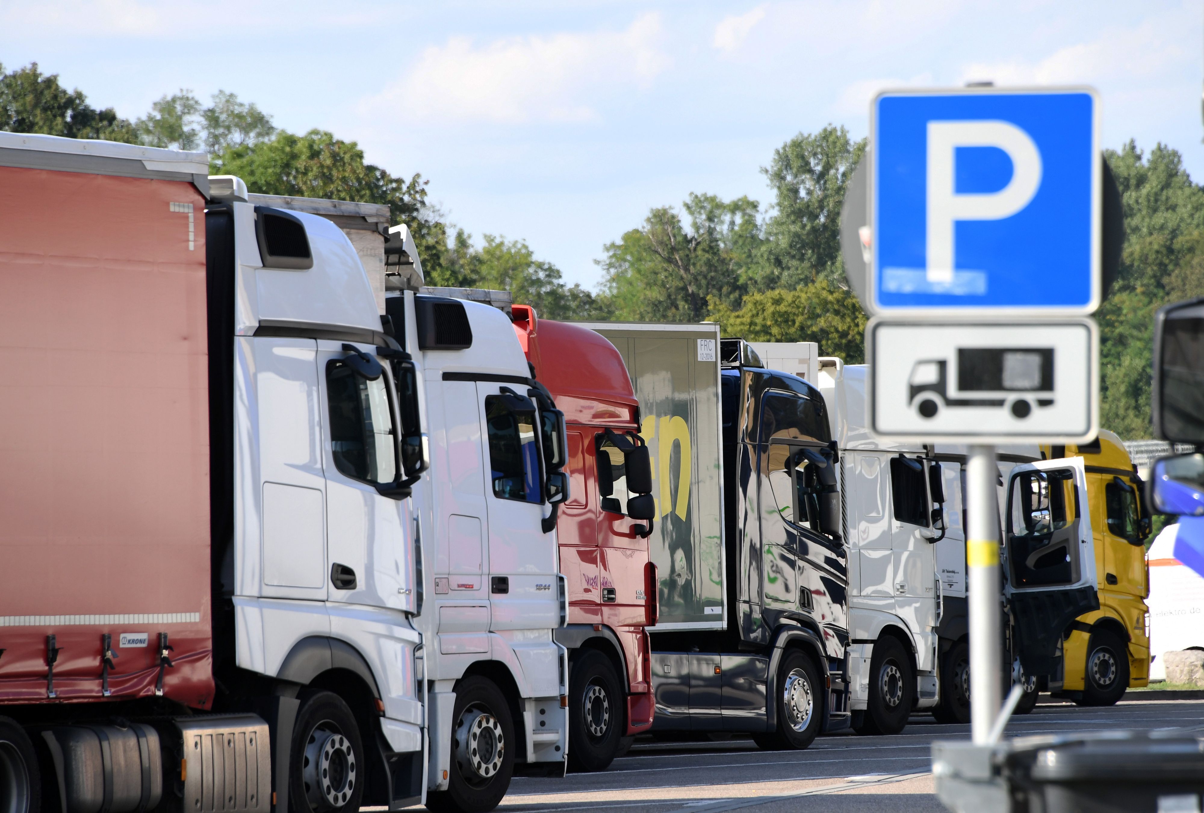 Lastwagen stehen auf einem Rastplatz dicht bei dicht.