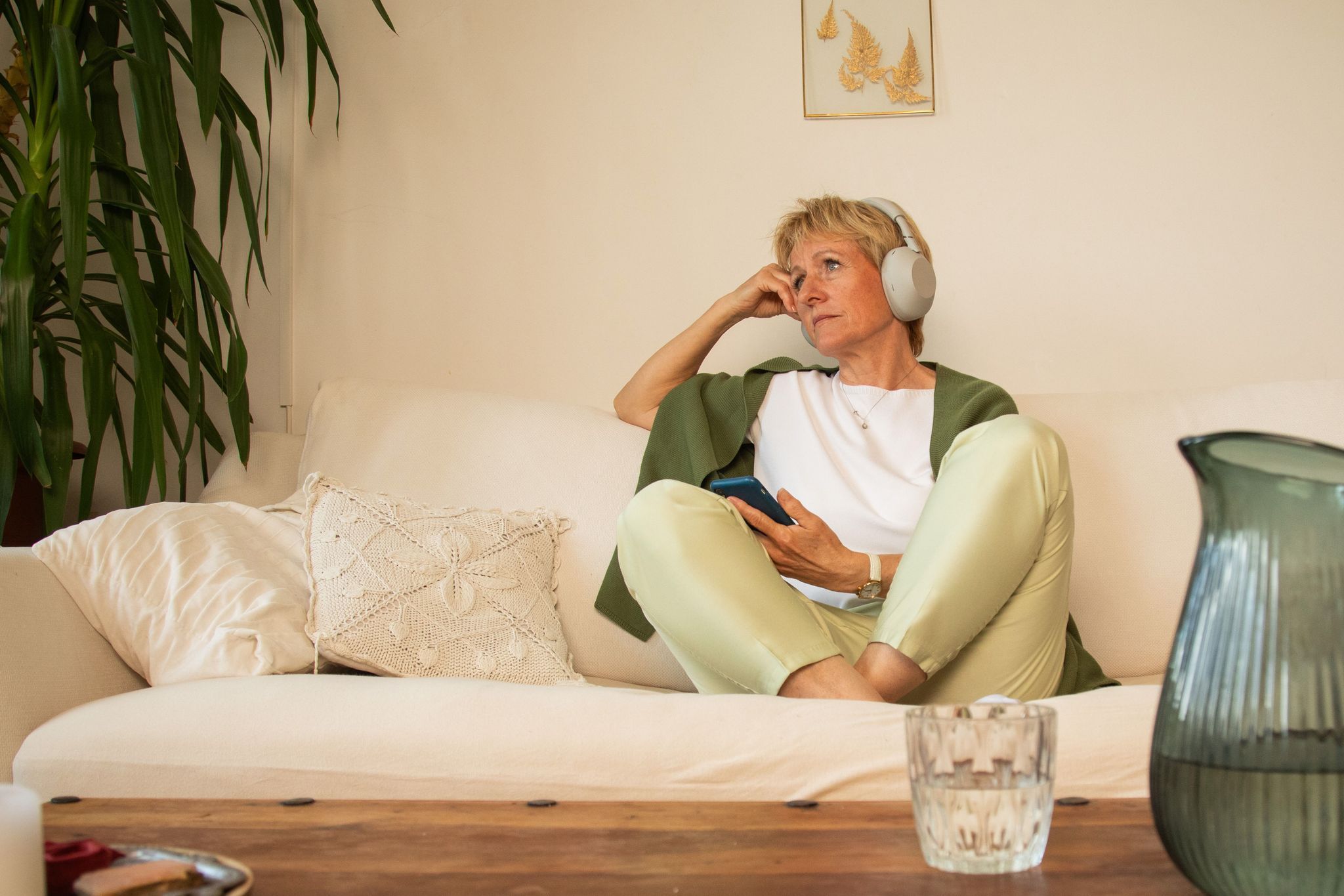 Eine Frau sitzt nachdenklich auf einem Sofa