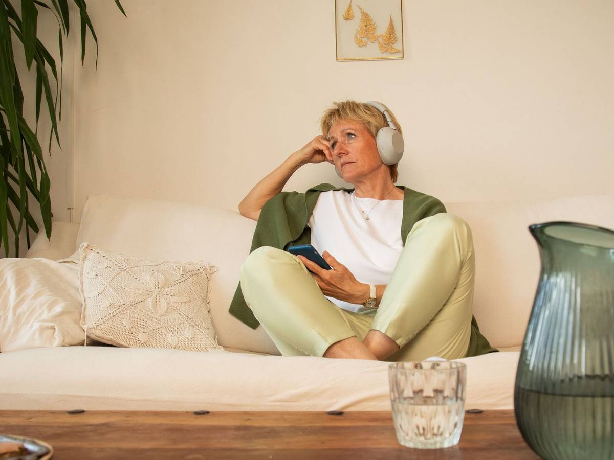 Eine Frau sitzt nachdenklich auf einem Sofa
