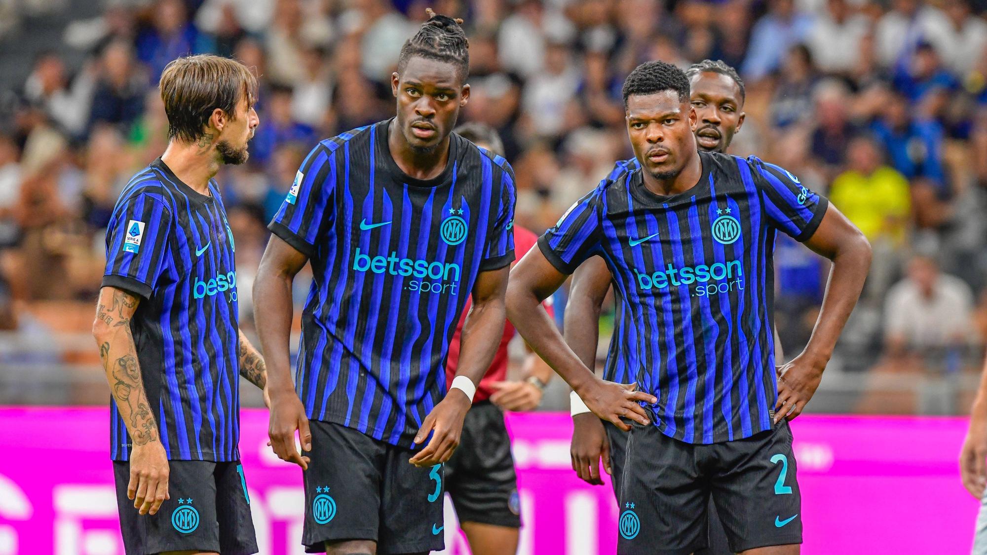 Denzel Dumfries (r.) und Yann Bisseck (M.) im Trikot von Inter Mailand auf dem Spielfeld.