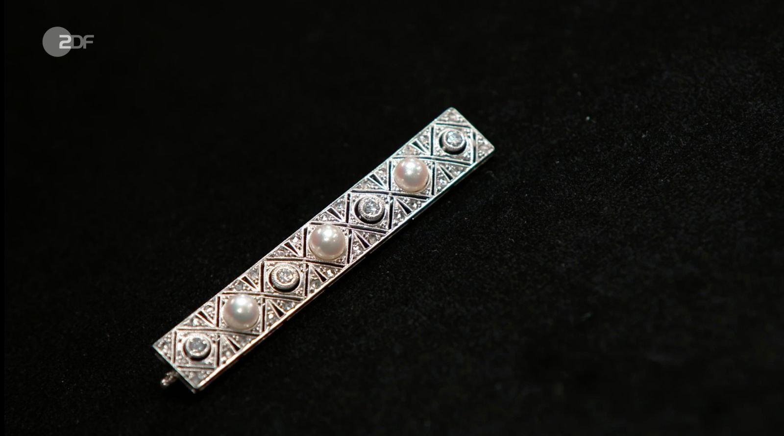 Als weiteres Objekt der Sendung wurde eine geerbte Stabbrosche aus 750er Weißgold mit Diamanten und Zuchtperlen von Heide Rezepa-Zabel in die 1920er-Jahre datiert. Gewünscht wurden 620 Euro, die Expertin schätzte 700 bis 900 Euro und Händlerin Sarah Schreiber zahlte 860 Euro für das Schmuckstück. (Bild: ZDF)