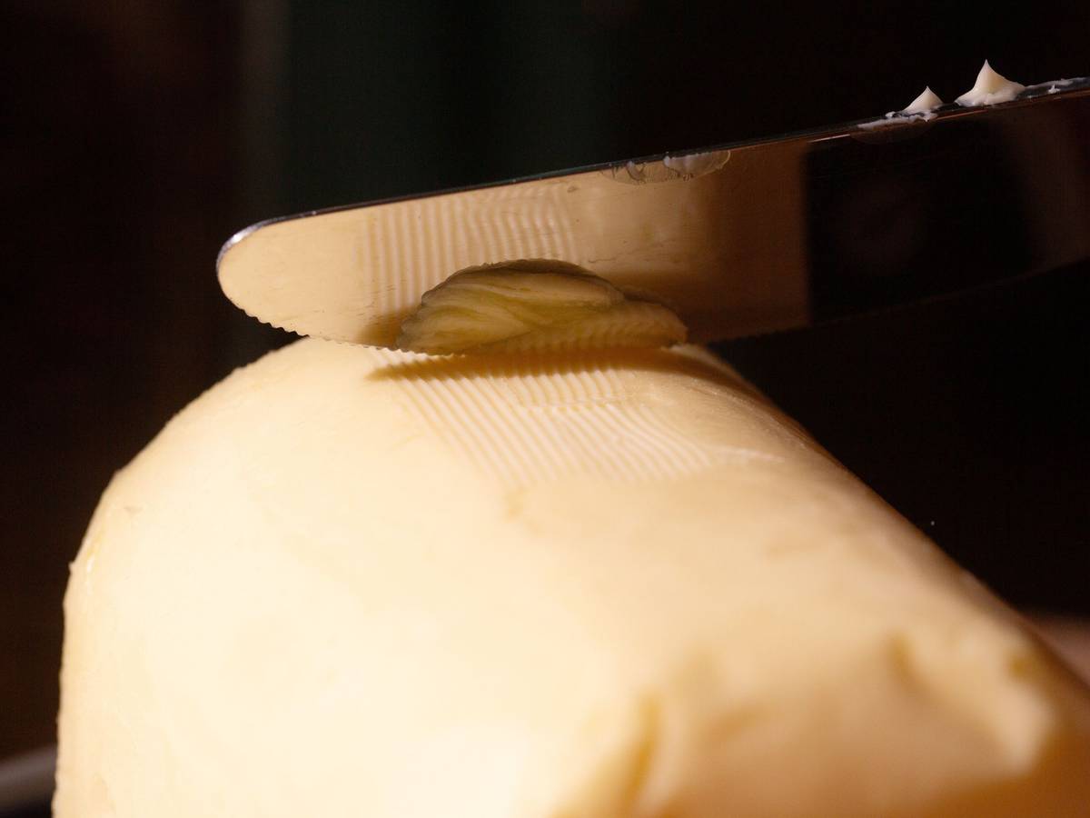 Ein Messer streicht über ein Stück Butter