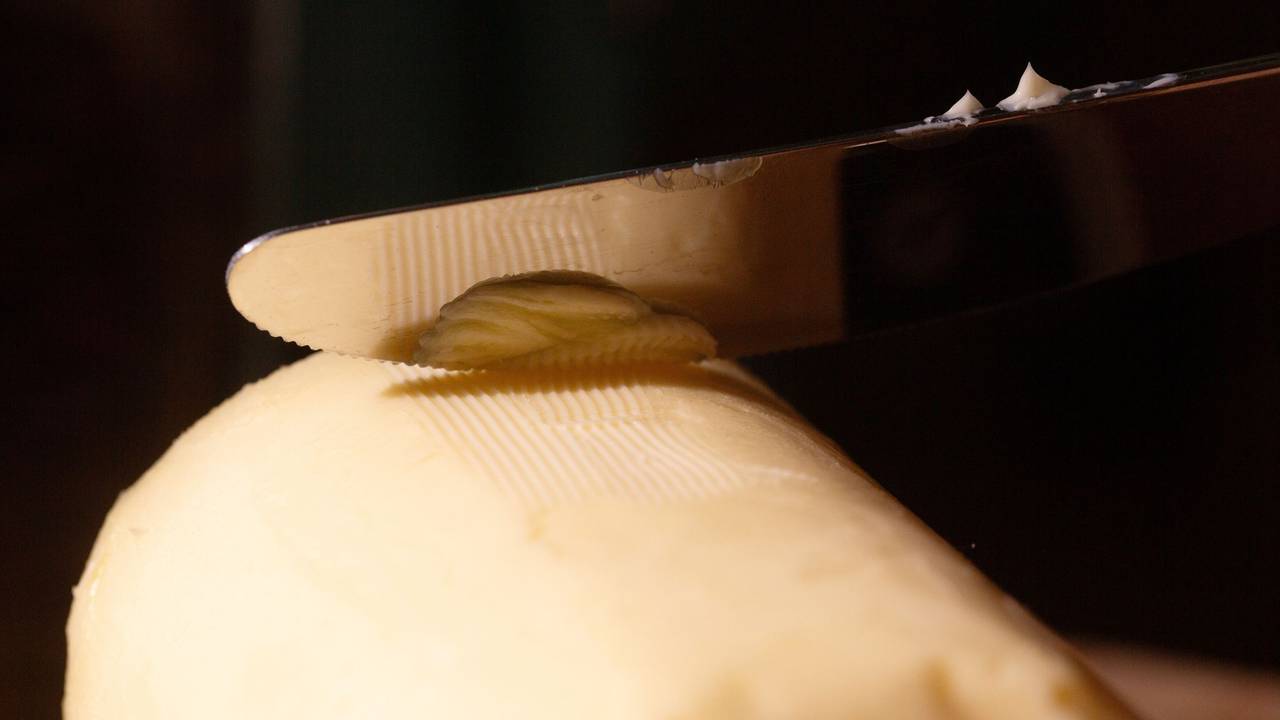 Ein Messer streicht über ein Stück Butter