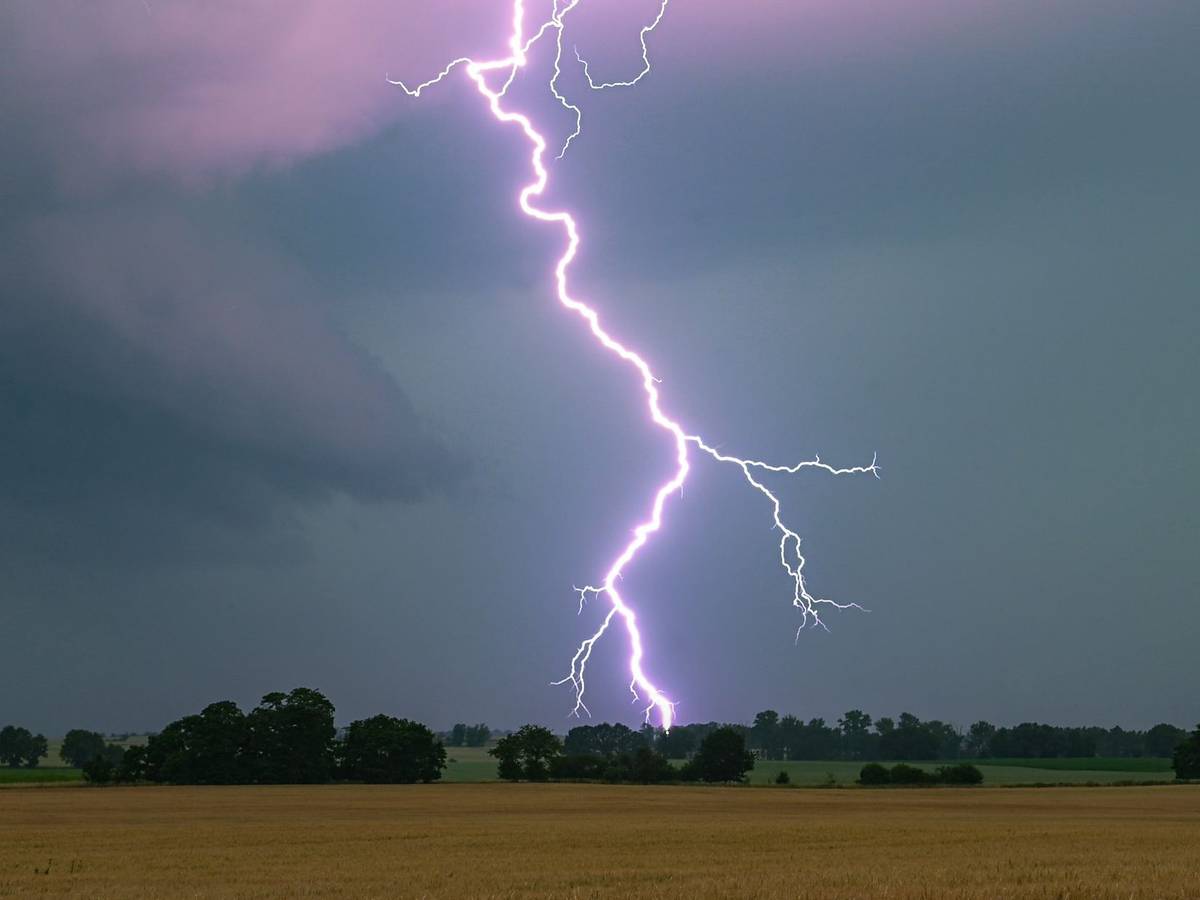 Ein Blitz leuchtet über einer Landschaft auf