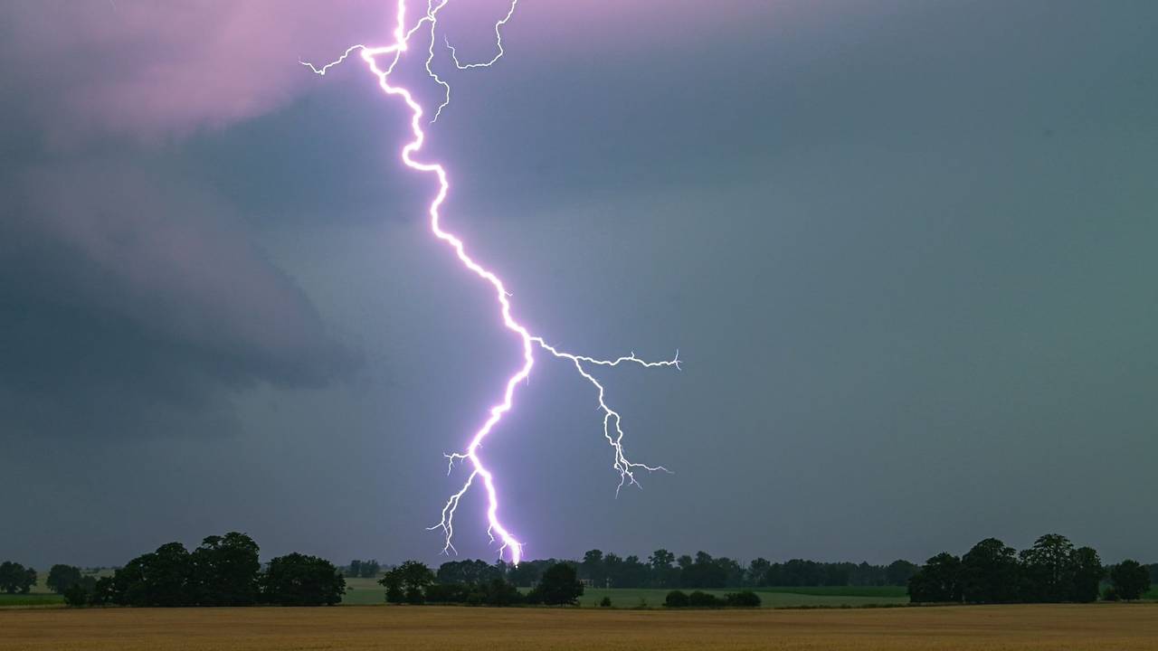 Ein Blitz leuchtet über einer Landschaft auf
