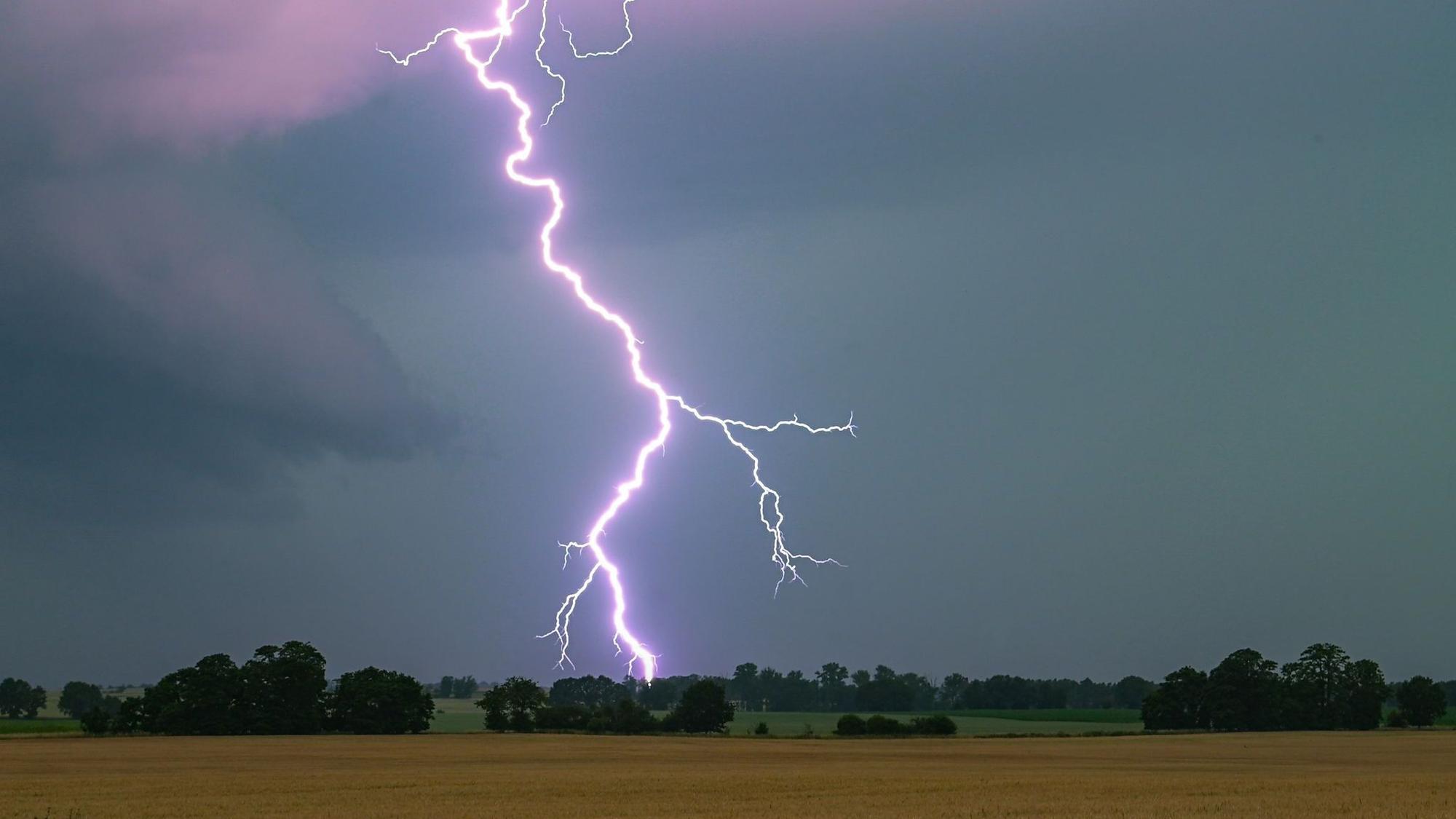 Ein Blitz leuchtet über einer Landschaft auf