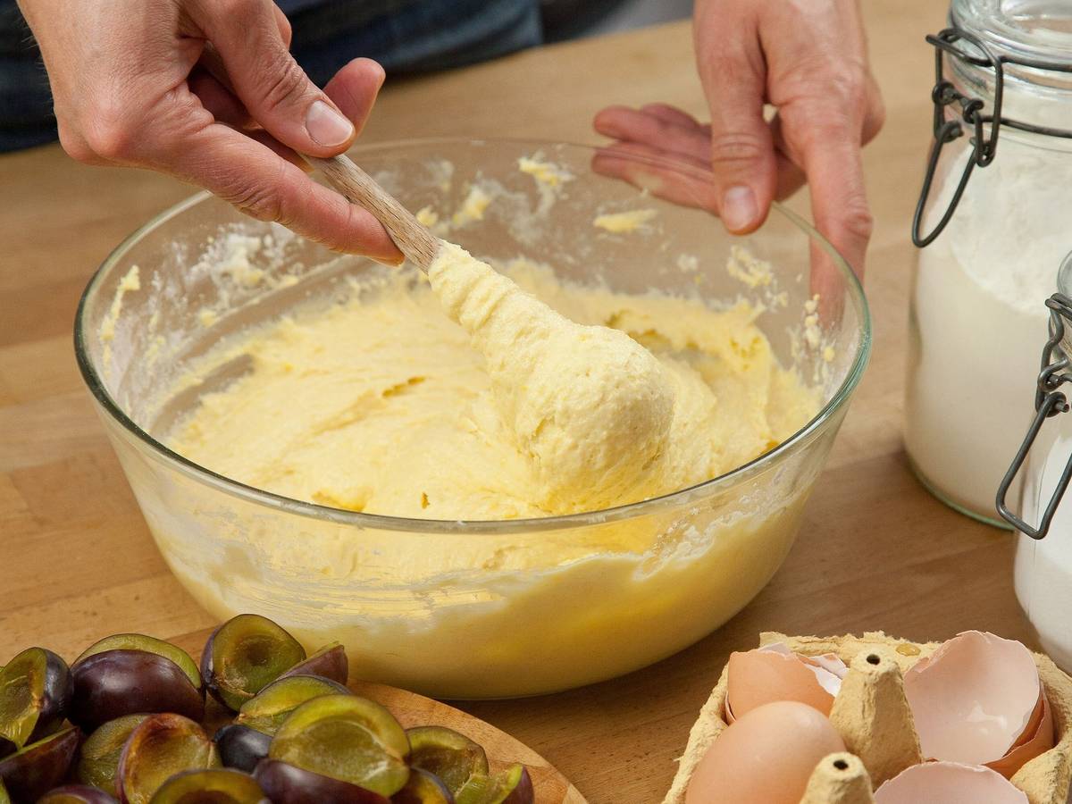 Eine Frau vermengt Zutaten für einen Rührteig