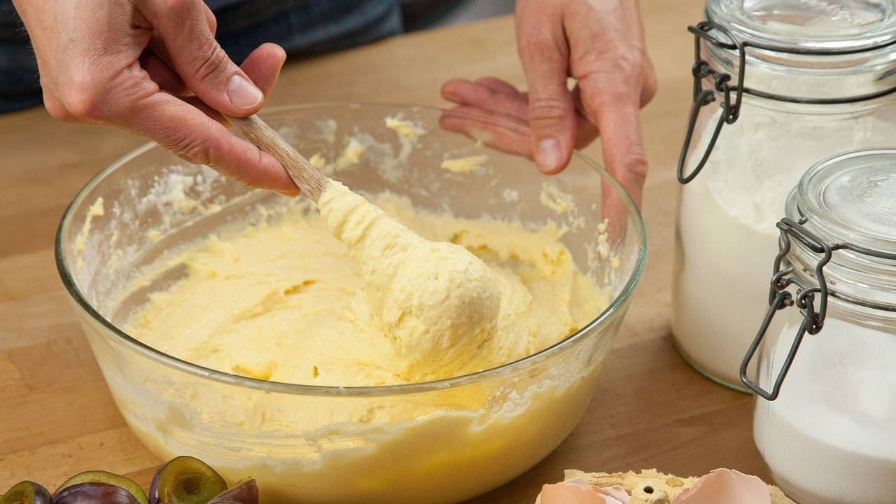 Eine Frau vermengt Zutaten für einen Rührteig