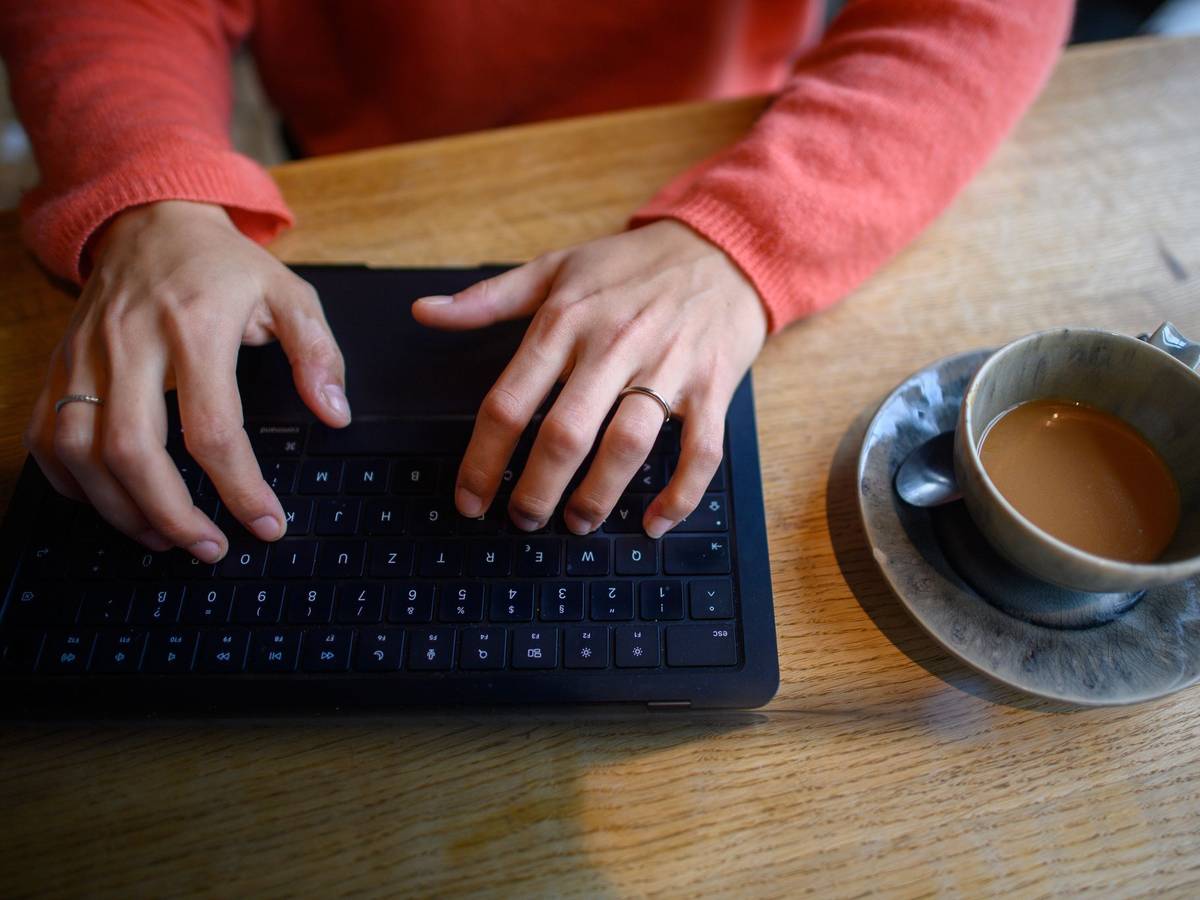 Eine Frau nutzt ihren Laptop in einem Café