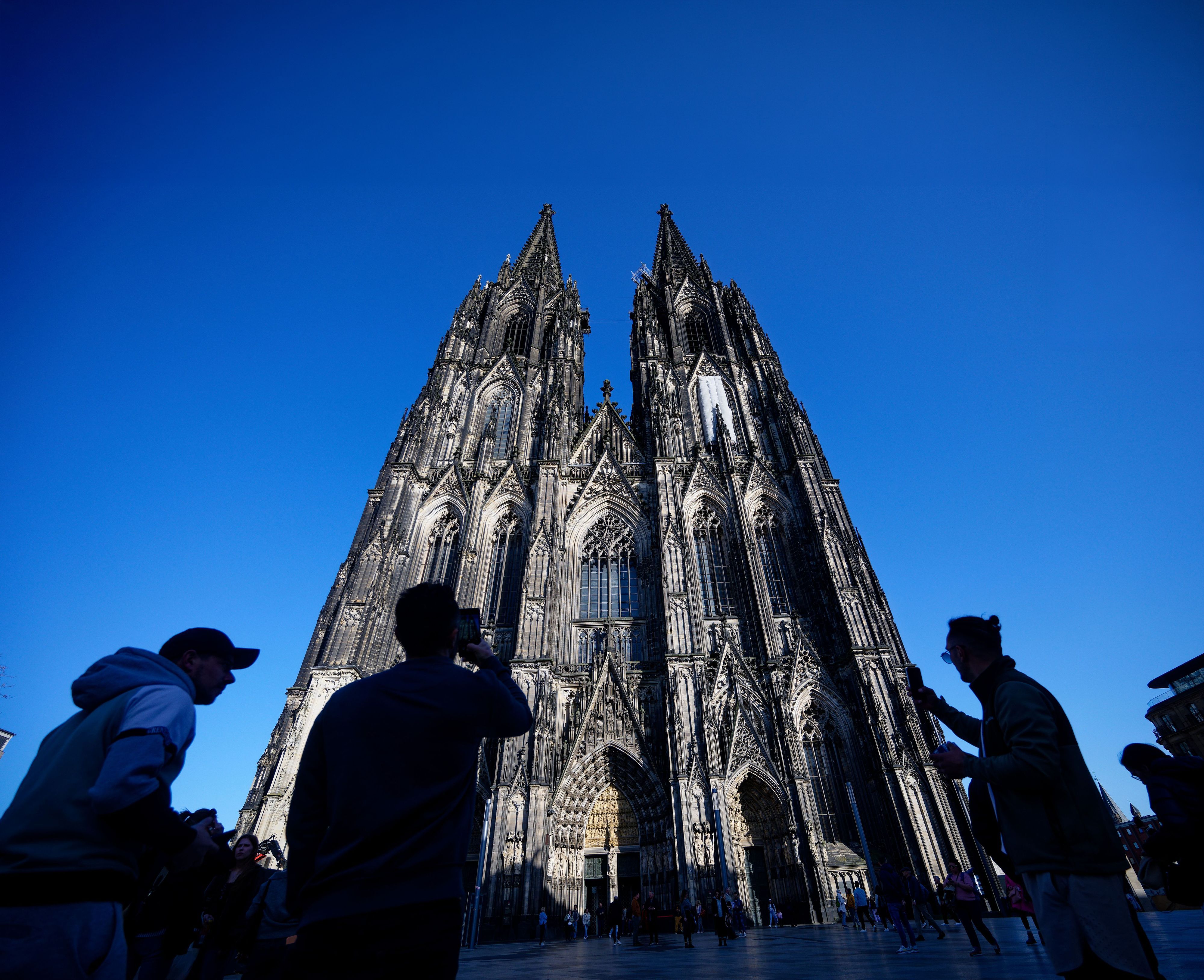 Touristen fotografieren den Kölner Dom.
