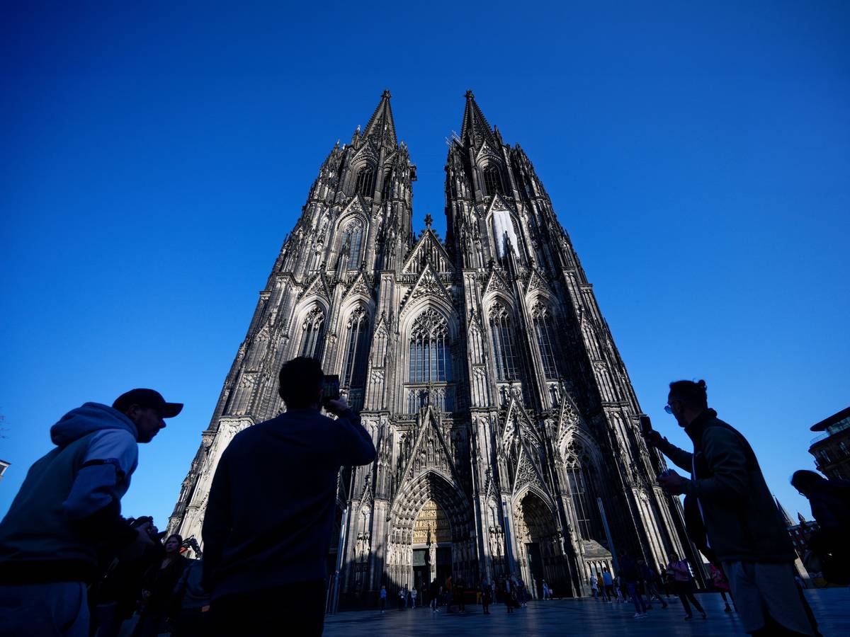 Touristen fotografieren den Kölner Dom.