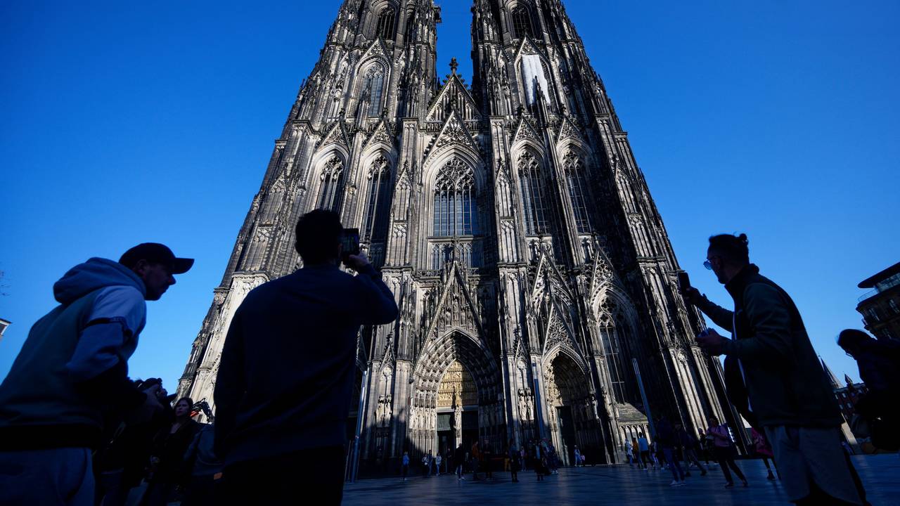 Touristen fotografieren den Kölner Dom.