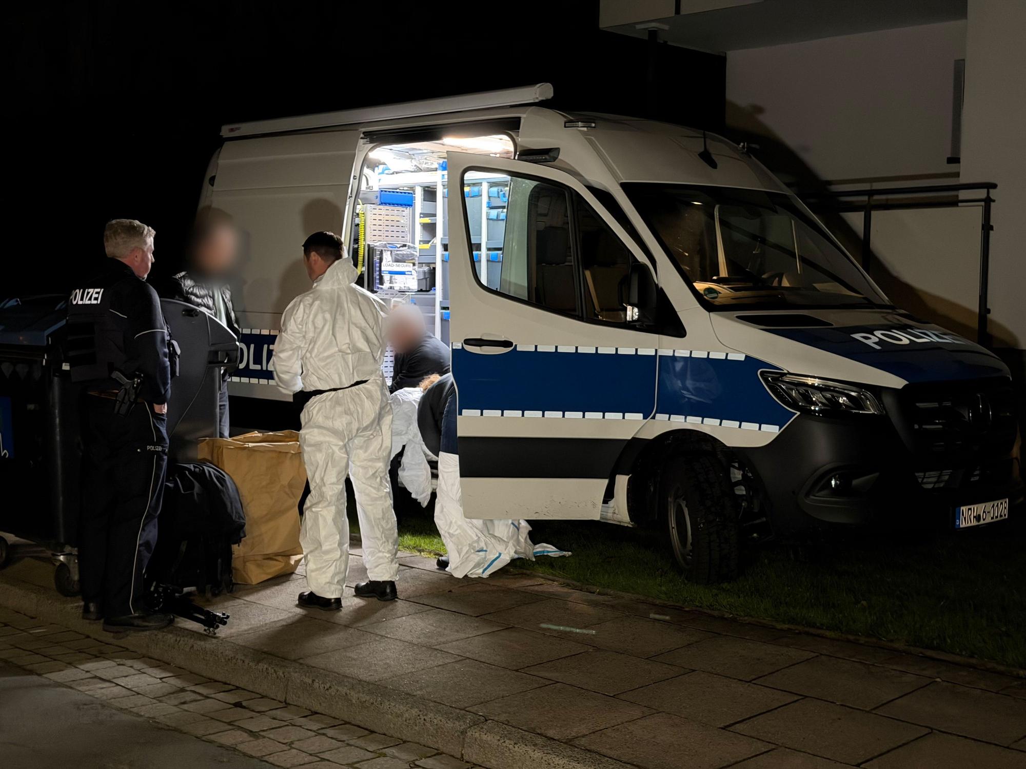 Polizei und Spurensicherung stehen vor einem Gebäude.