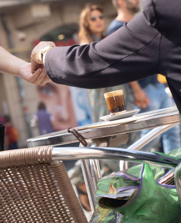 Eine Frau bedient in einem Café einen Gast