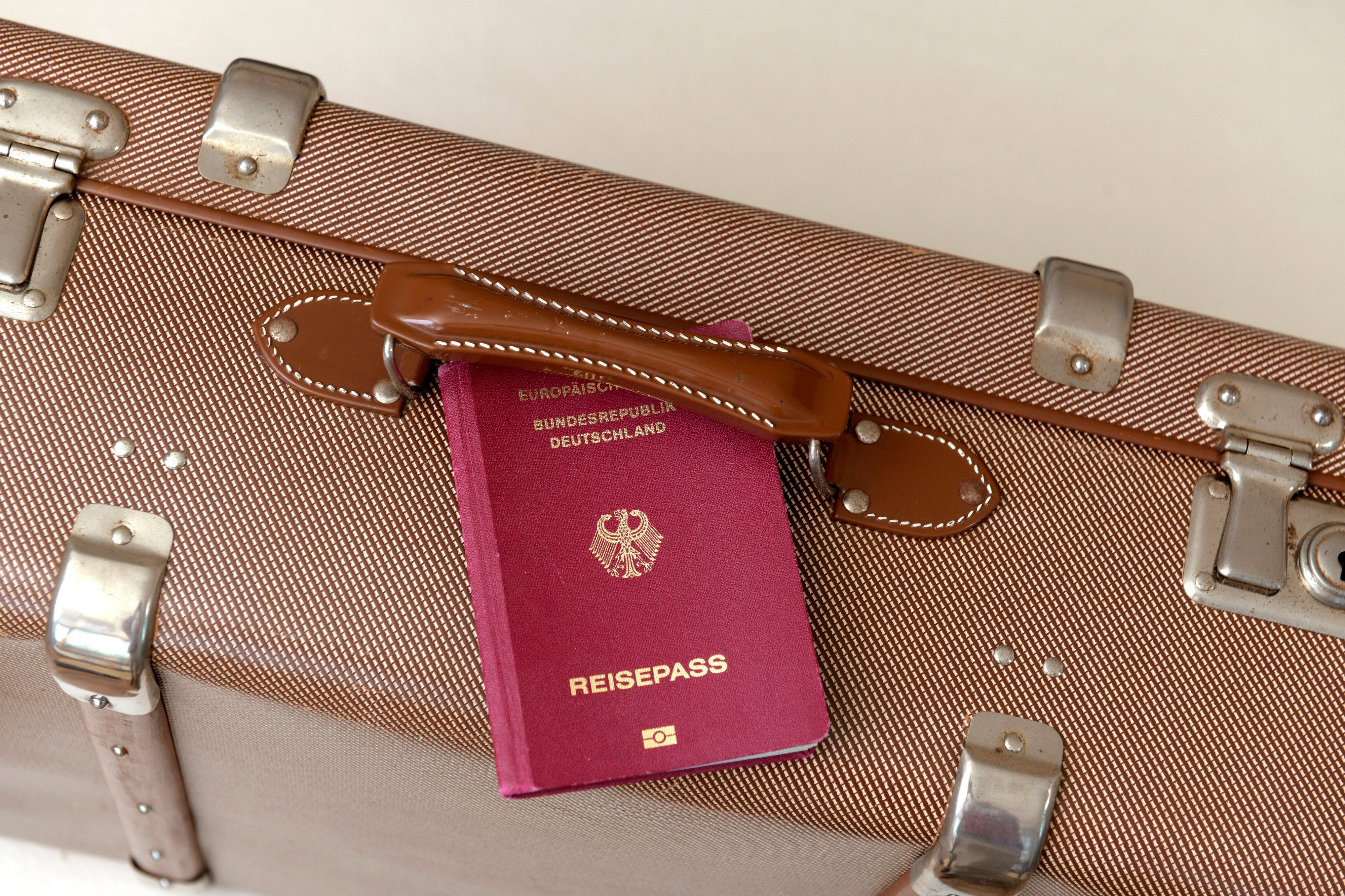 Ein deutscher Reisepass und ein Reisekoffer
