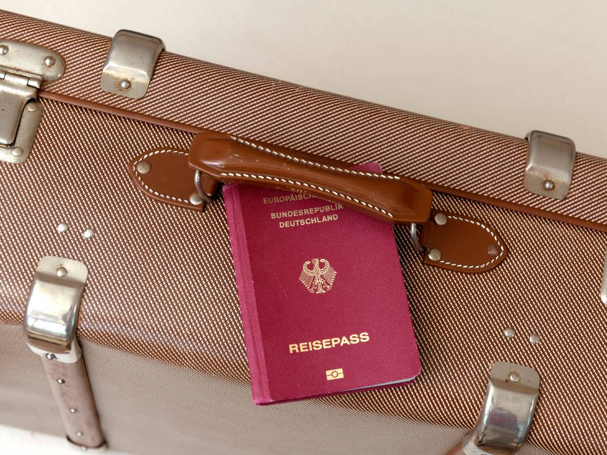Ein deutscher Reisepass und ein Reisekoffer