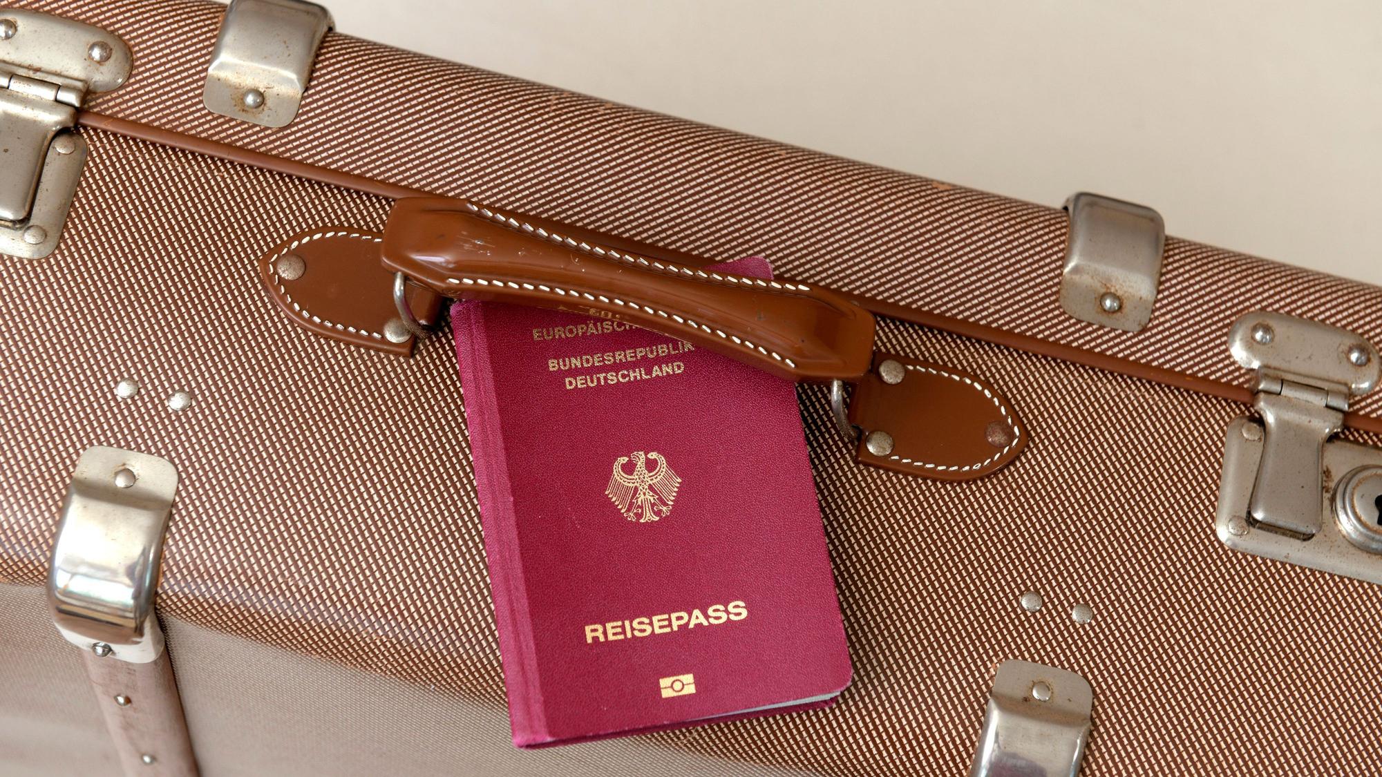 Ein deutscher Reisepass und ein Reisekoffer