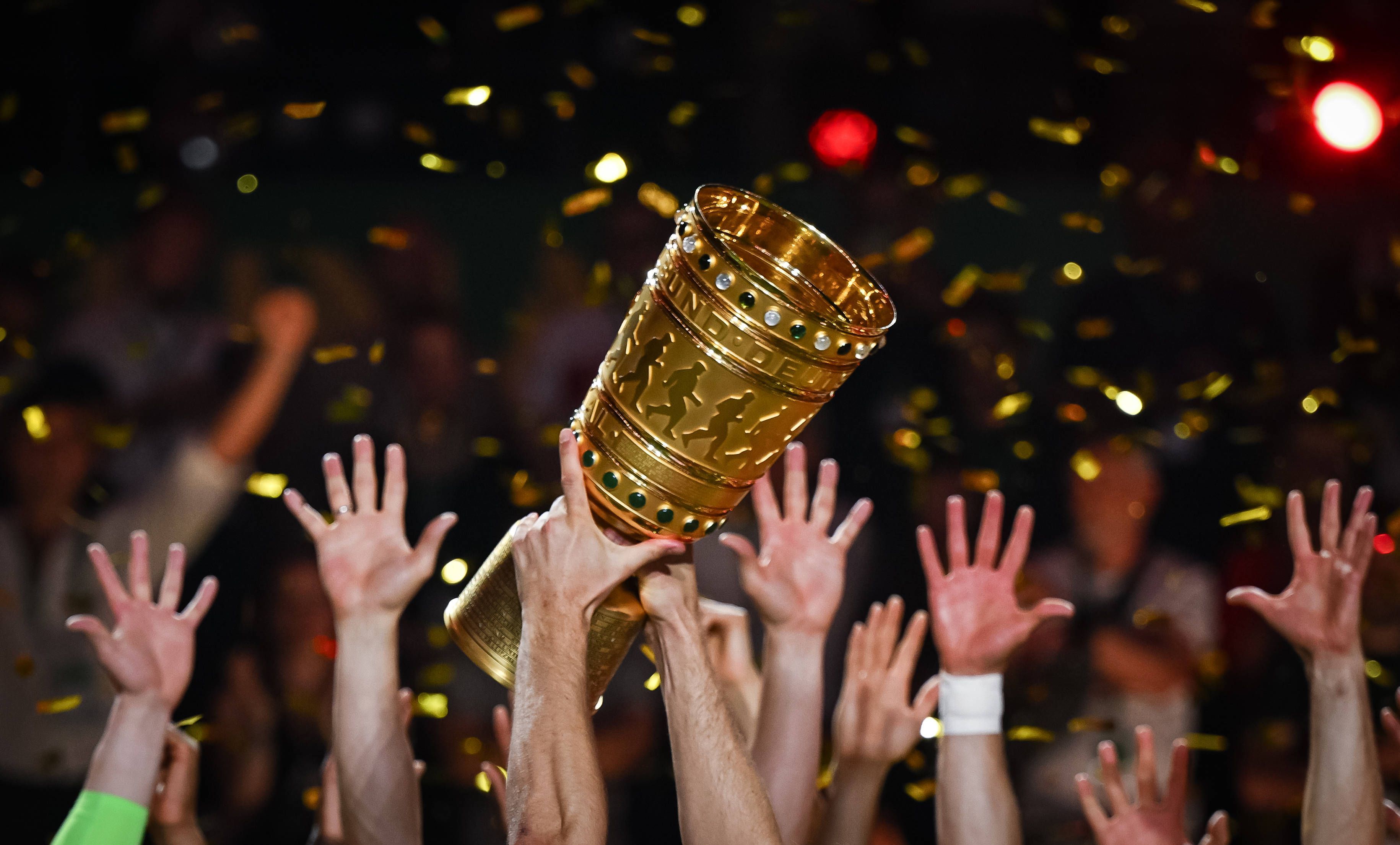 Hände von Spielern recken den DFB-Pokal in die Höhe.