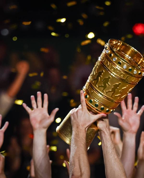 Hände von Spielern recken den DFB-Pokal in die Höhe.
