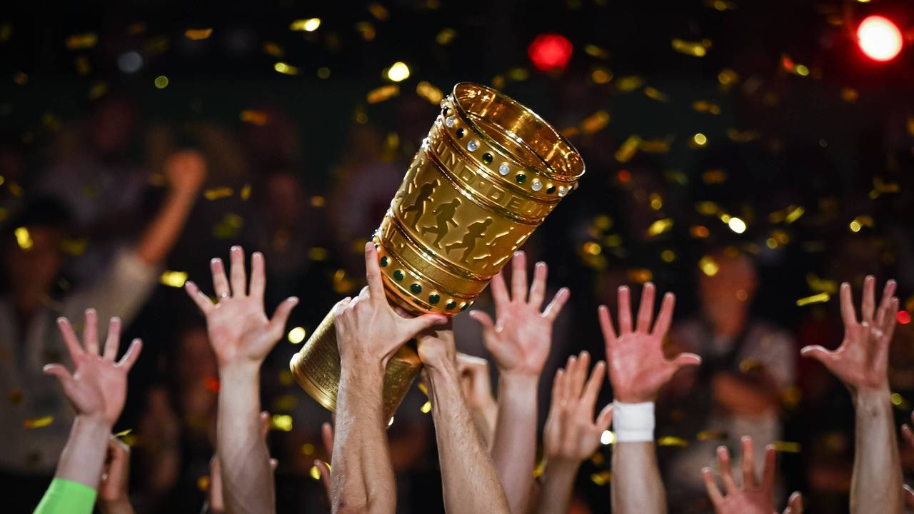 Hände von Spielern recken den DFB-Pokal in die Höhe.