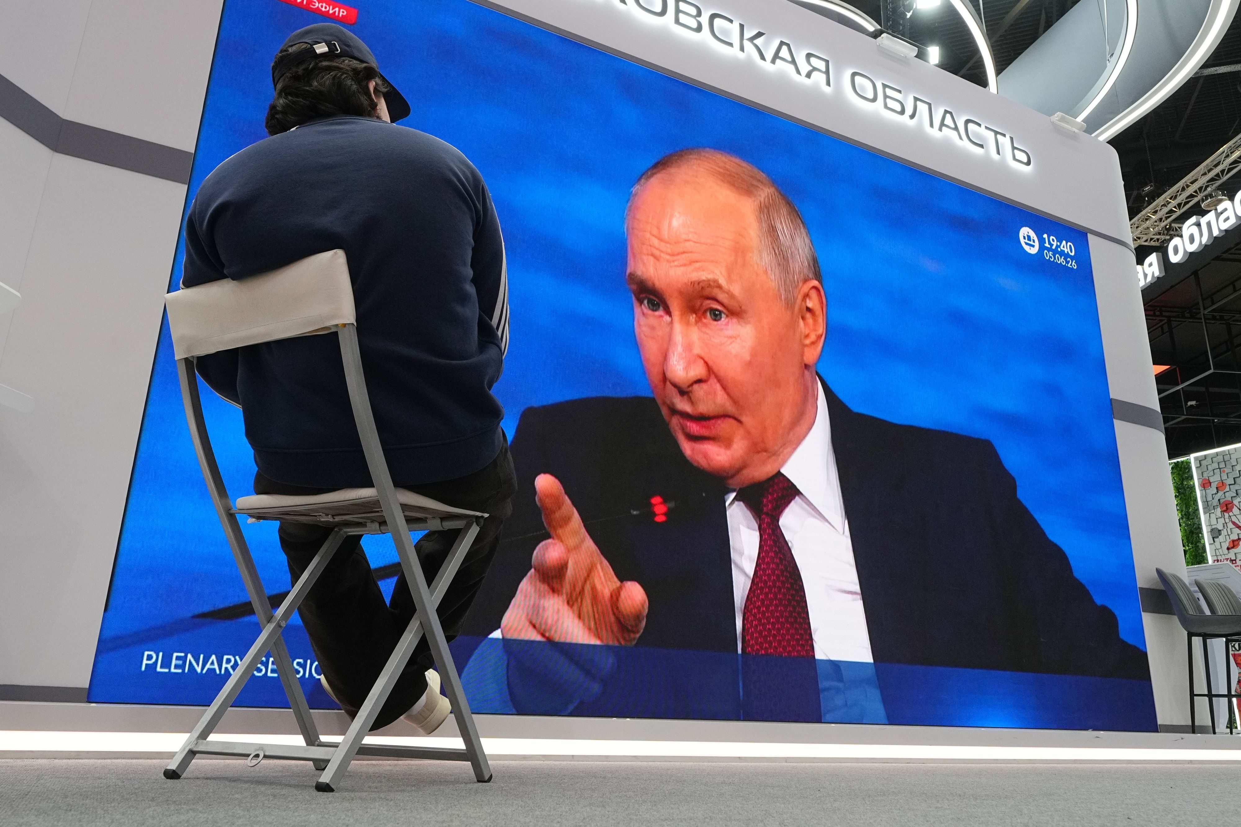 Wladimir Putin spricht auf einer Leinwand.