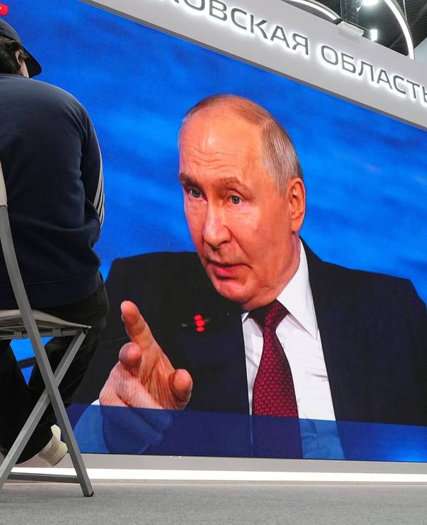 Wladimir Putin spricht auf einer Leinwand.