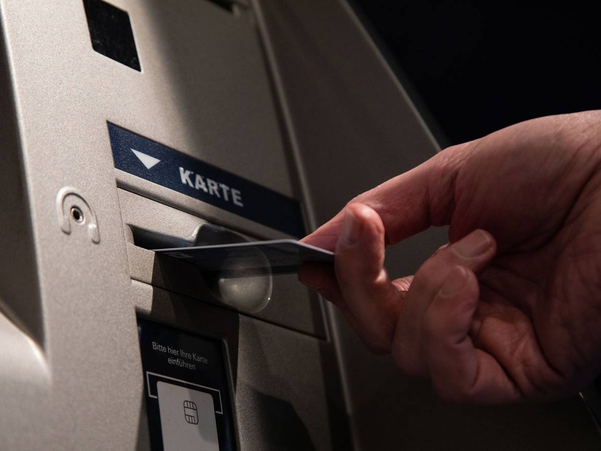 Ein Mann mit Karte an einen Bankautomaten