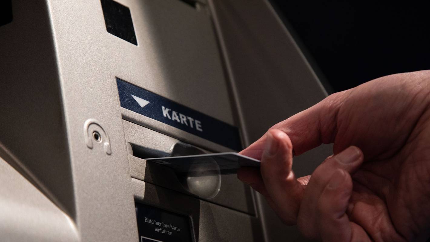 Ein Mann mit Karte an einen Bankautomaten