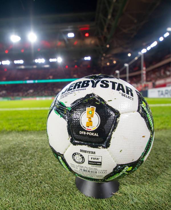 Ein Derbystar-Ball des DFB-Pokals liegt auf dem Rasen. Im Hintergrund sieht man das Stadion von Fortuna Düsseldorf.
