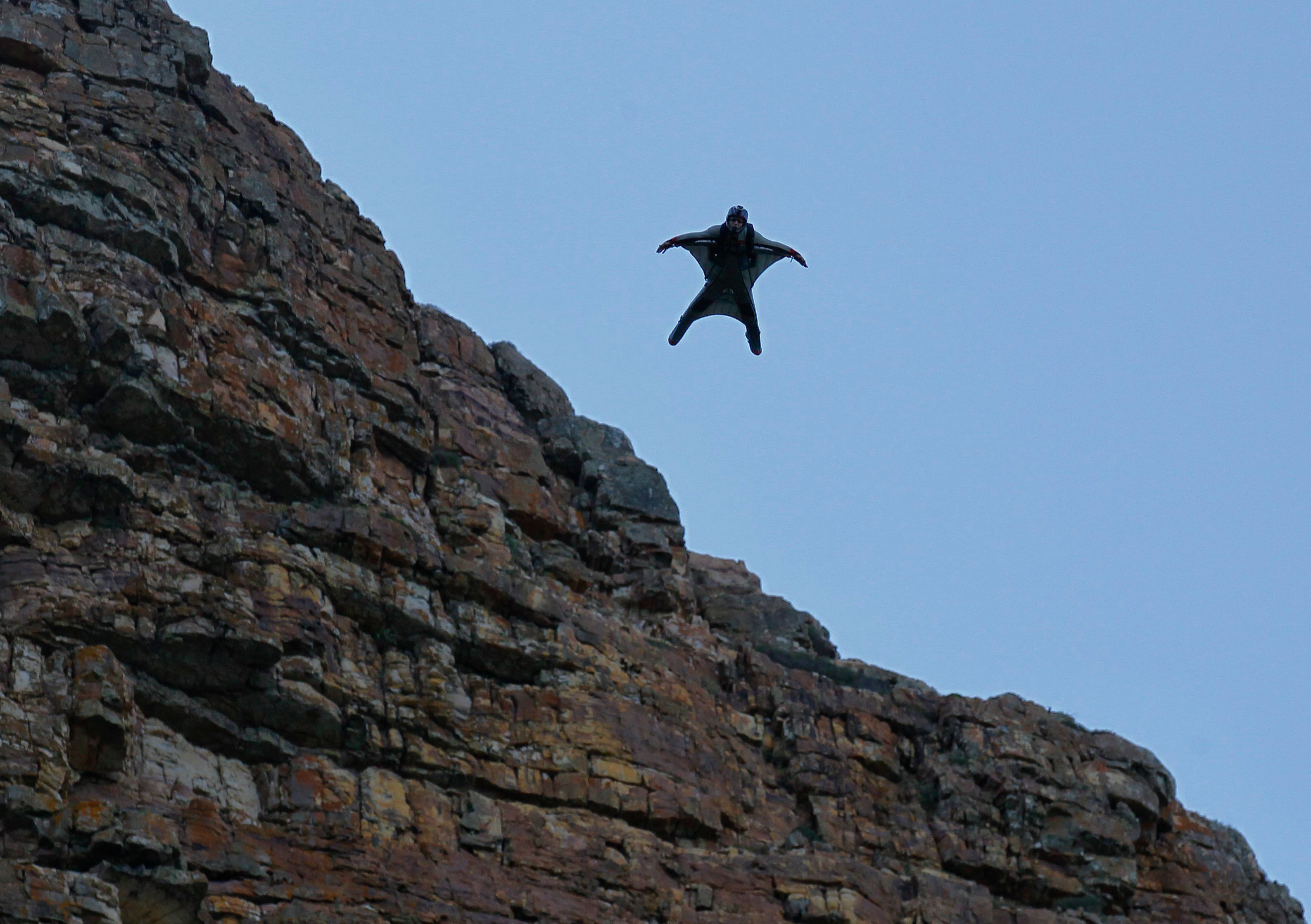 Eine Person, die einen Wingsuit trägt, fliegt durch die Luft.