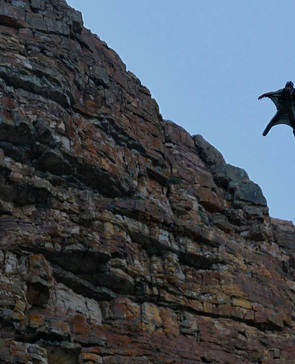 Eine Person, die einen Wingsuit trägt, fliegt durch die Luft.