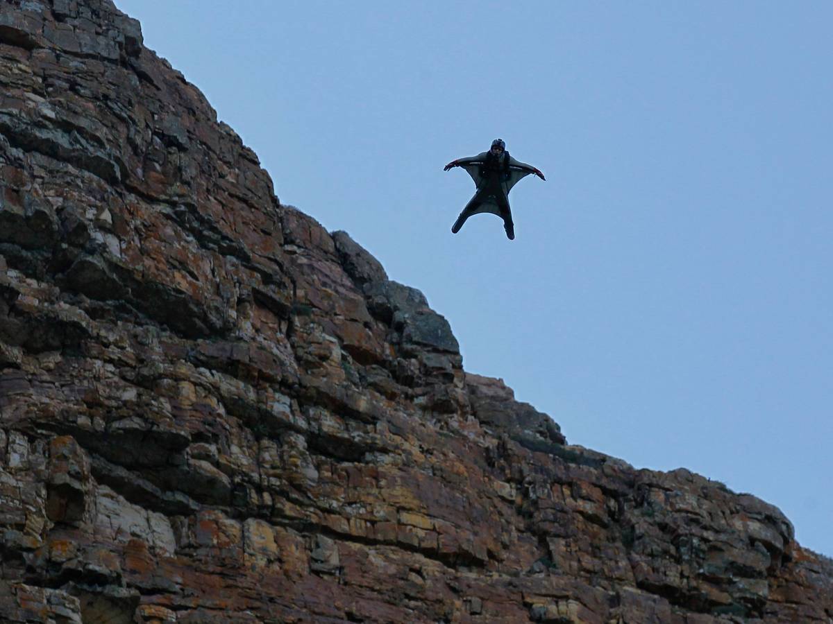 Eine Person, die einen Wingsuit trägt, fliegt durch die Luft.