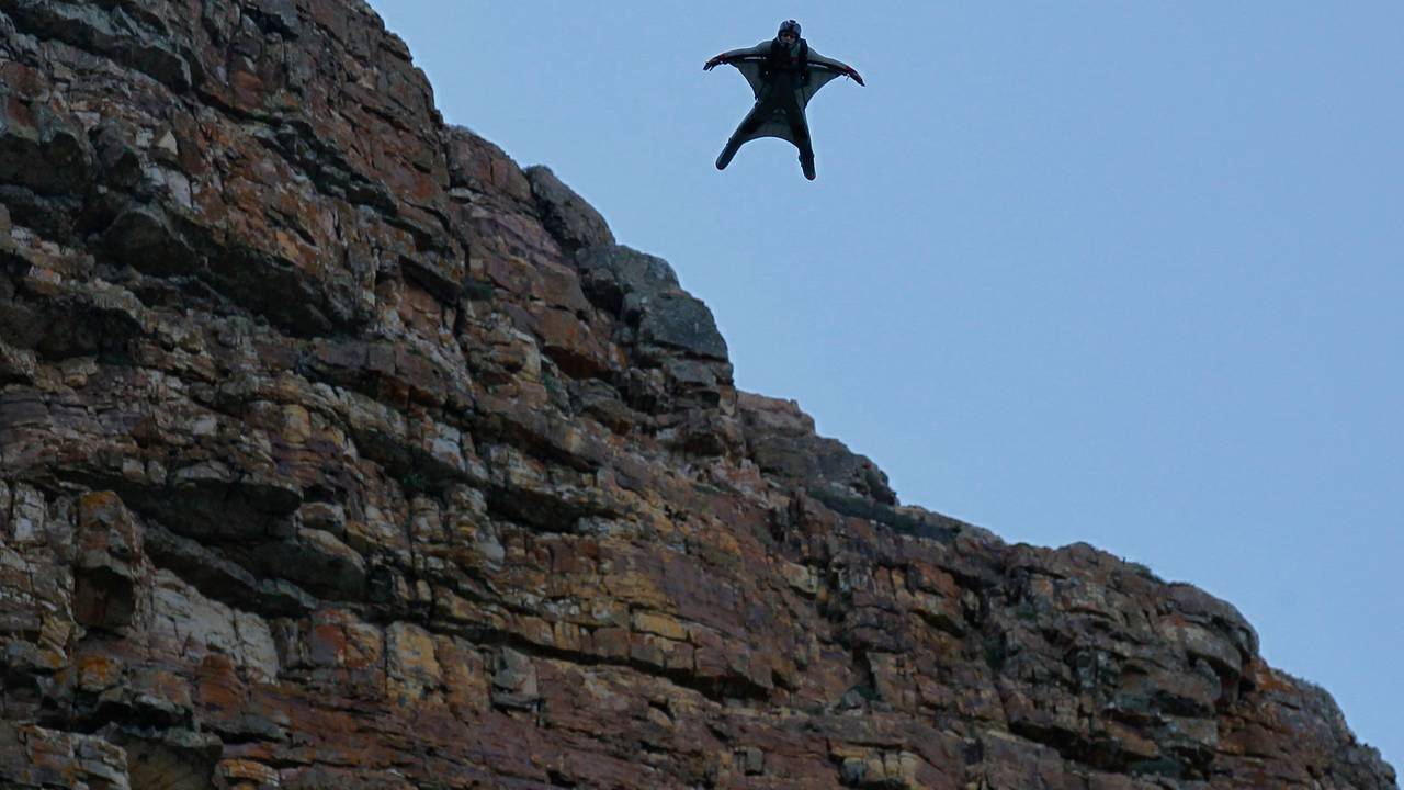 Eine Person, die einen Wingsuit trägt, fliegt durch die Luft.