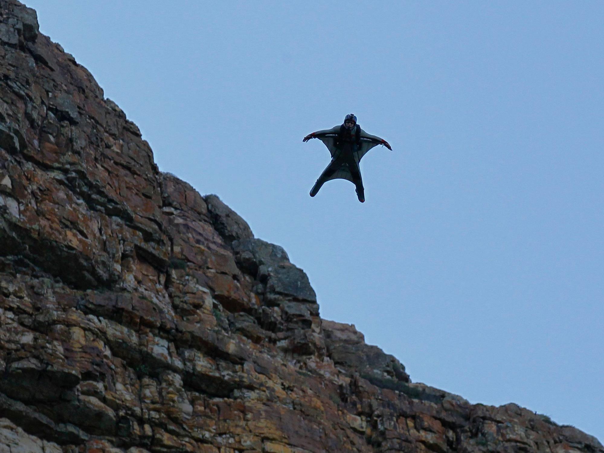 Eine Person, die einen Wingsuit trägt, fliegt durch die Luft.