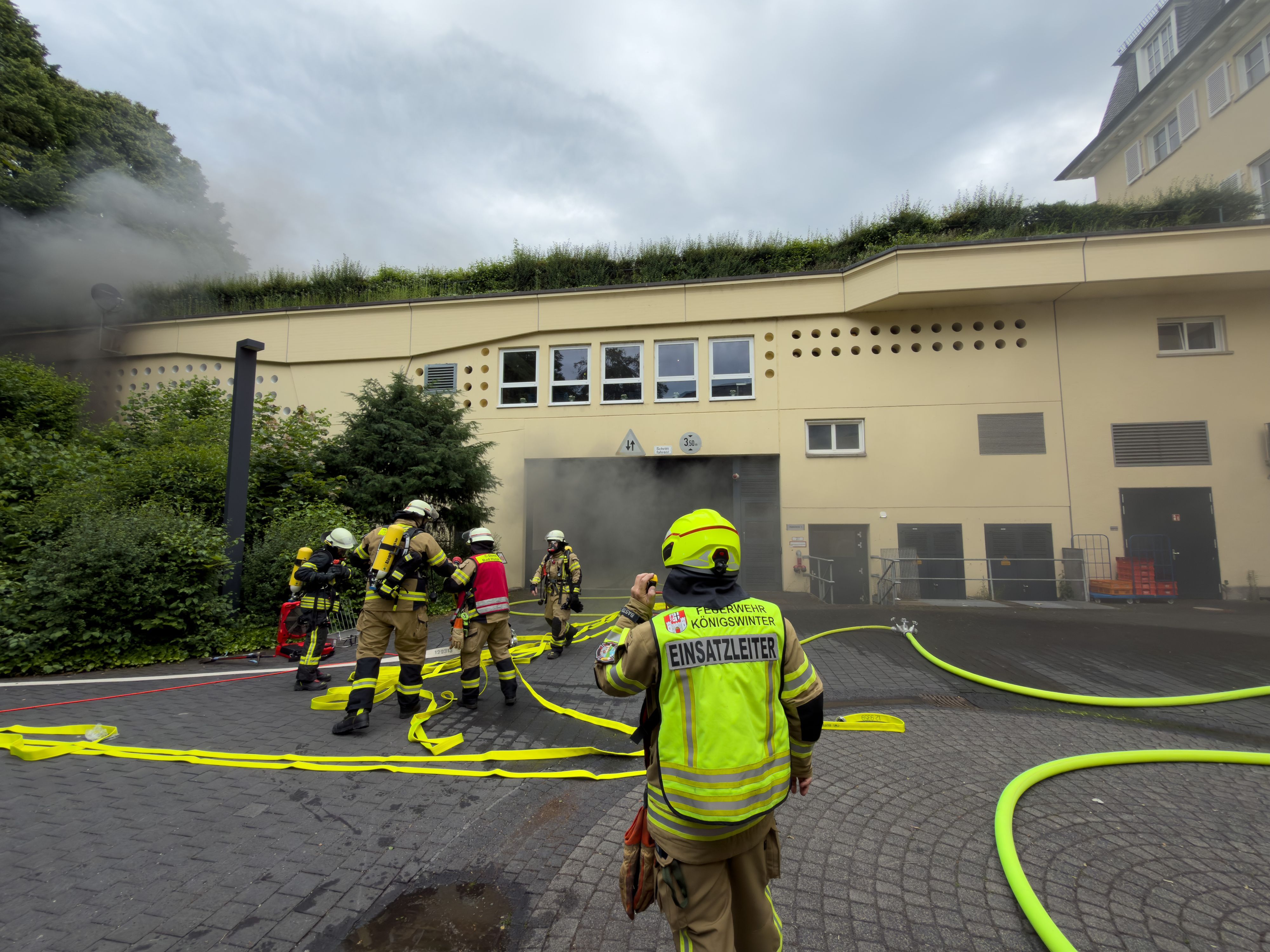 Feuerwehrleute im Einsatz am Grandhotel Petersberg, aus der Hotelgarage qualmt es.
