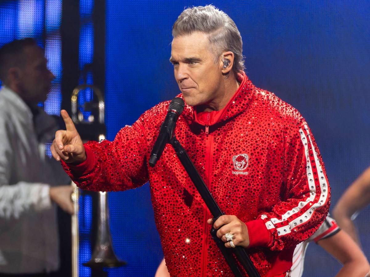 Robbie Williams steht beim Auftritt auf der Bühne.