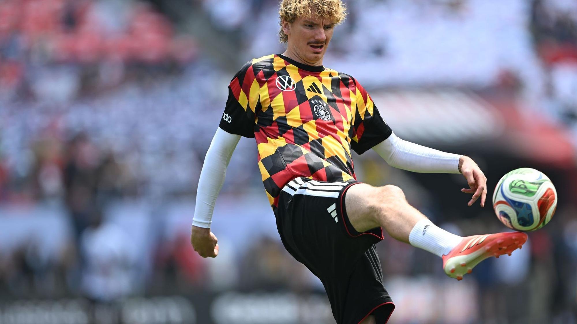 Die DFB-Spieler um Nick Woltemade wärmten sich in auffälligen Shirts auf.