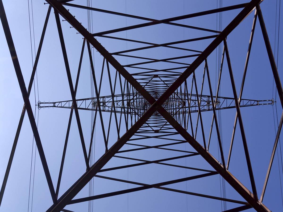 Stromleitungen und Strommast vor blauem Himmel