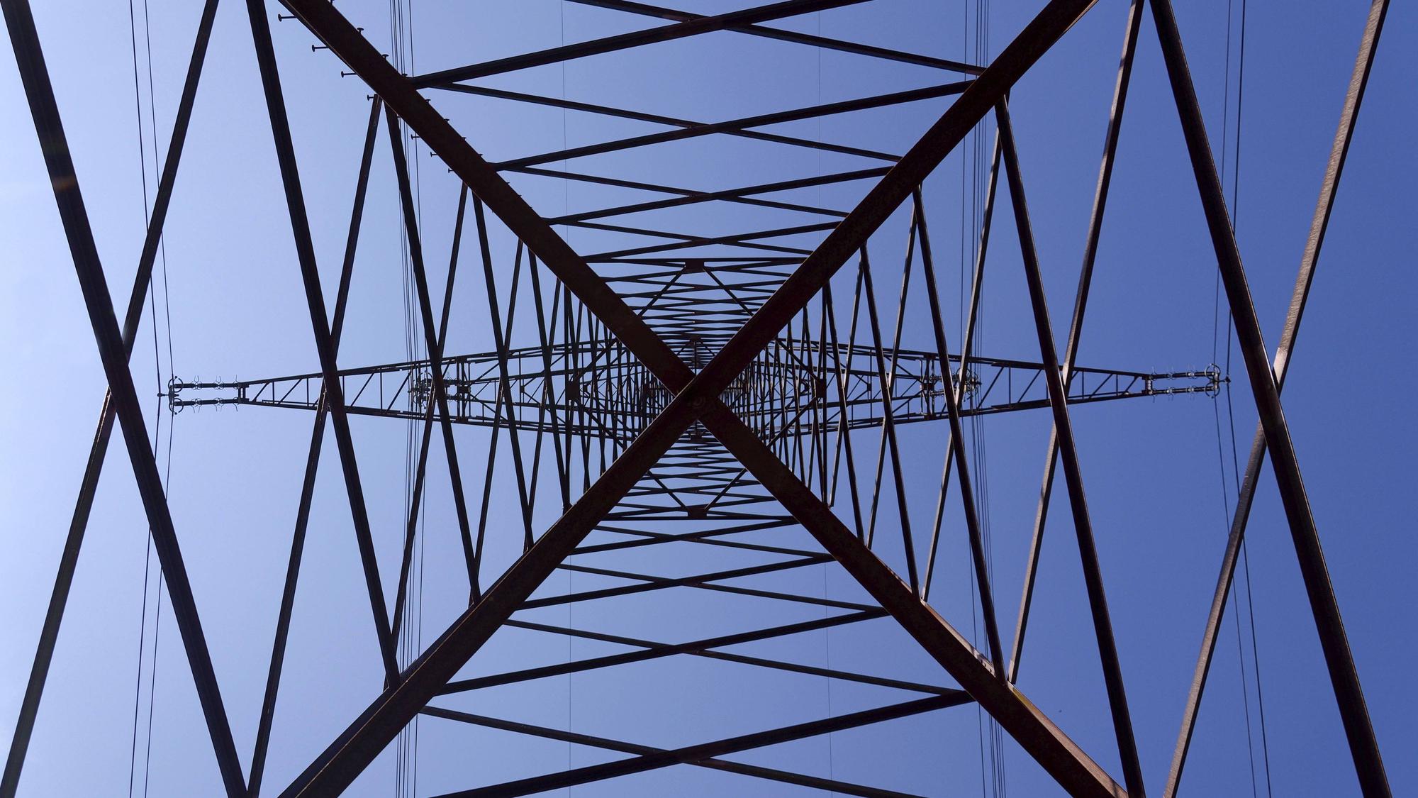Stromleitungen und Strommast vor blauem Himmel
