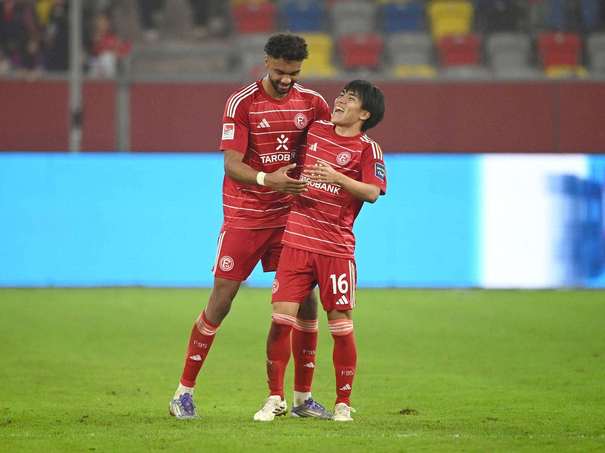 Elias Egouli und Satoshi Tanaka (r.) mit guter Laune auf dem Spielfeld.