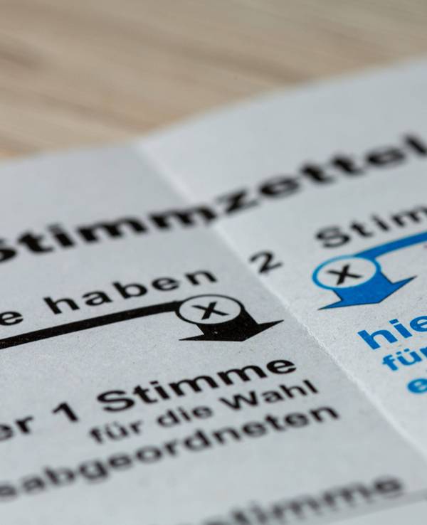 Stimmzettel mit Text und Pfeilen