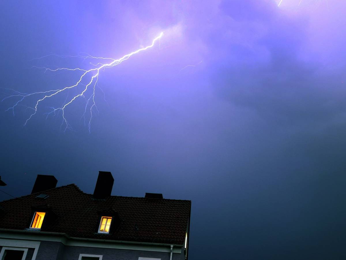 Blitze über einem Wohnhaus während eines Gewitters