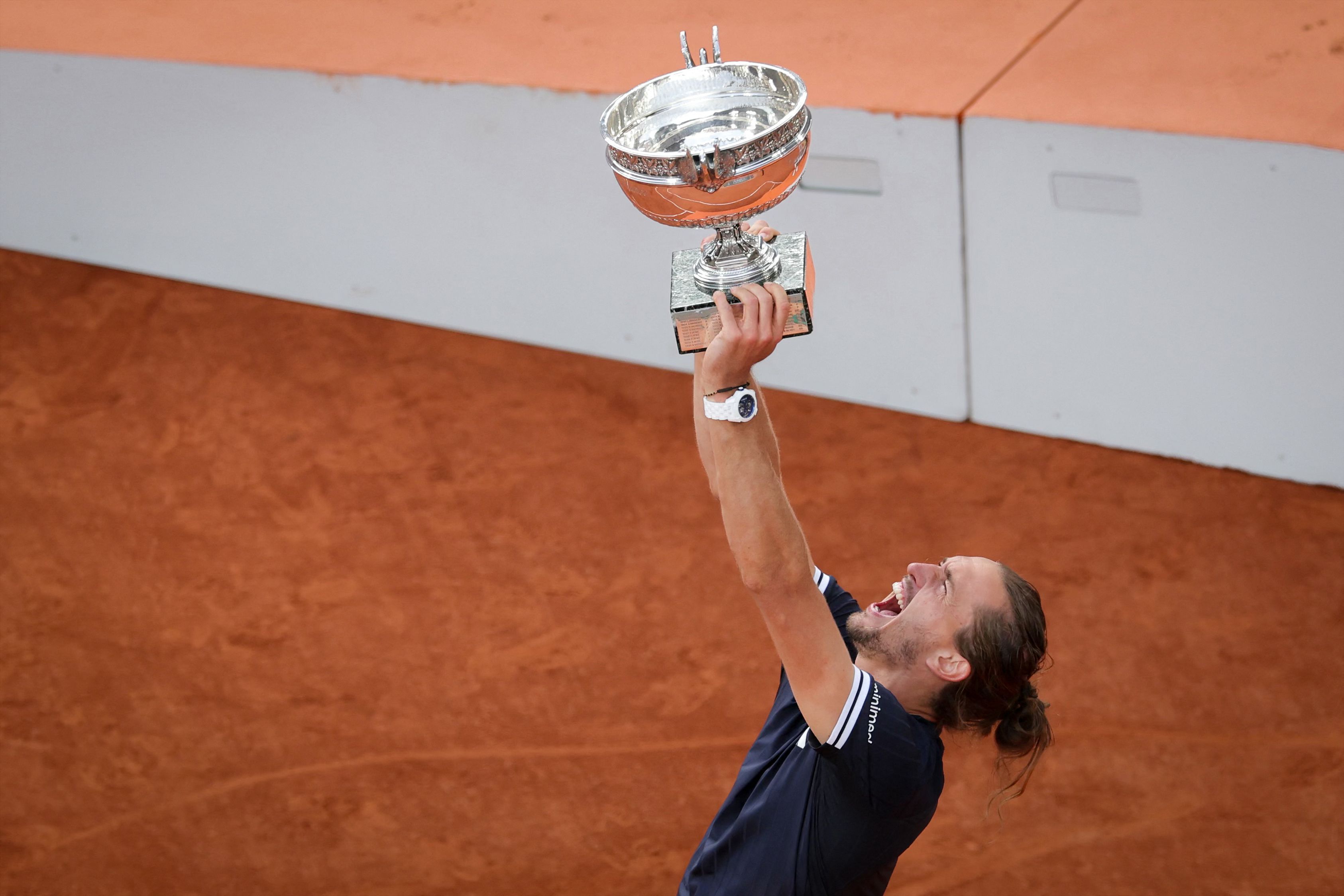 Alexander Zverev gewinnt das Finale der French Open und reckt die Trophäe in die Höhe.
